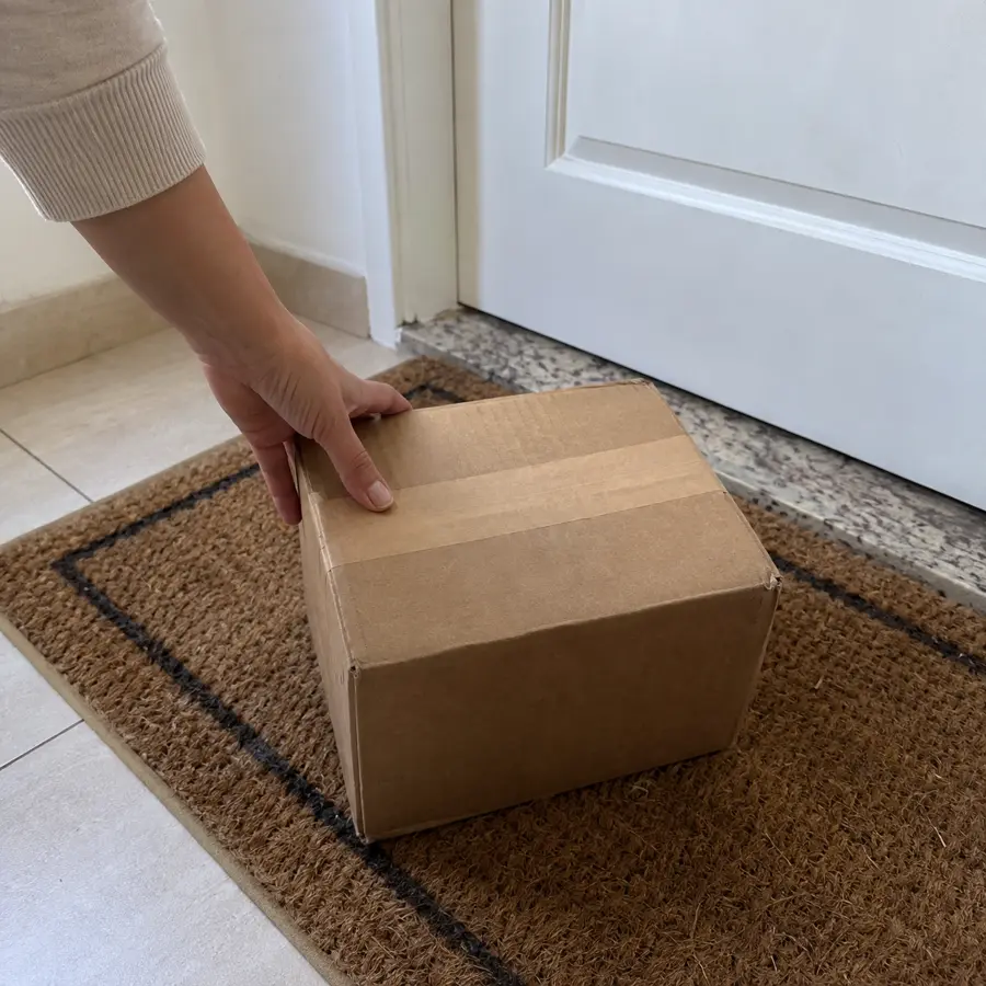 Caixa de papelão lisa, sem nome do produto, entregue na porta de casa